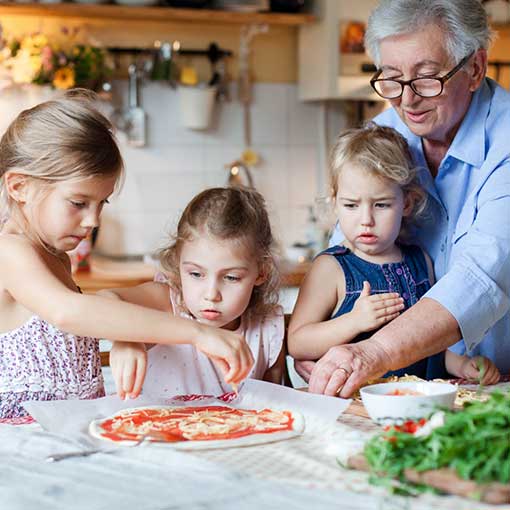 Family making a pizza together.