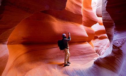 A young man exploring the inside of a canyon