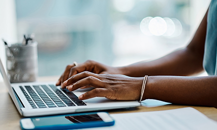 A woman sitting at a desk working on her laptop.