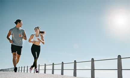 A woman and man enjoying a run on a sunny day.