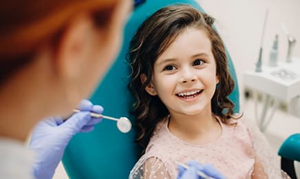 A child smiling at her dentist