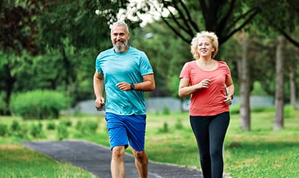 A man and a woman jogging outdoors.