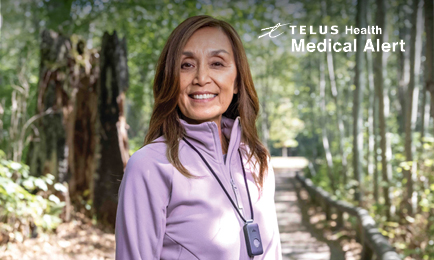 Woman smiling during a walk with TELUS logo in the background.