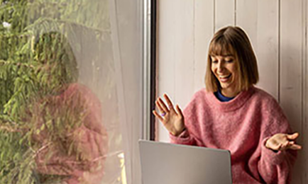 Girl having a cheerful conversation through the computer.