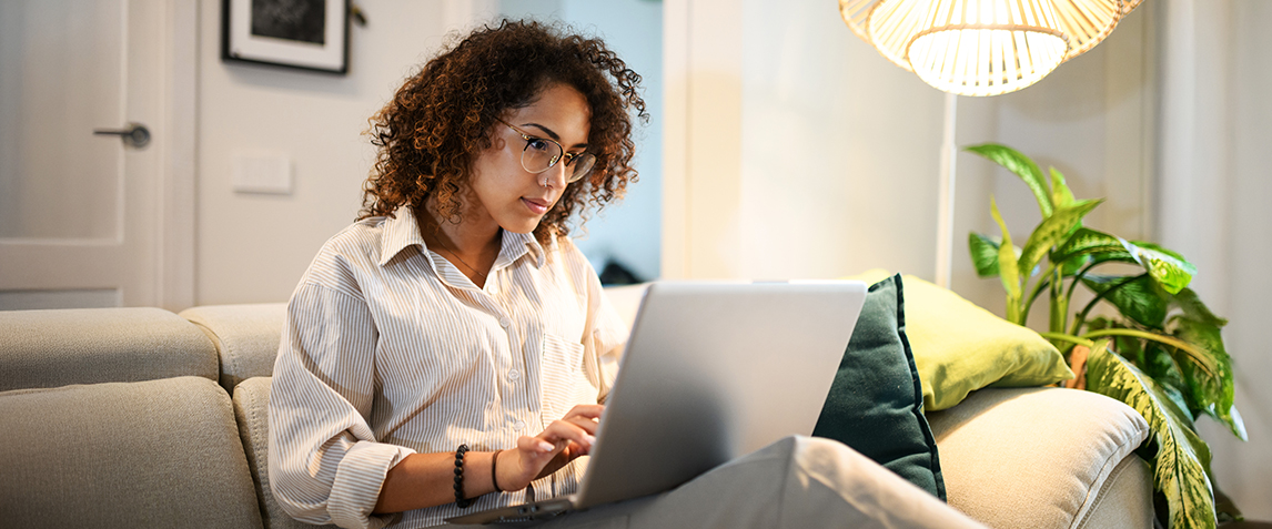 A woman using her laptop in the living room.