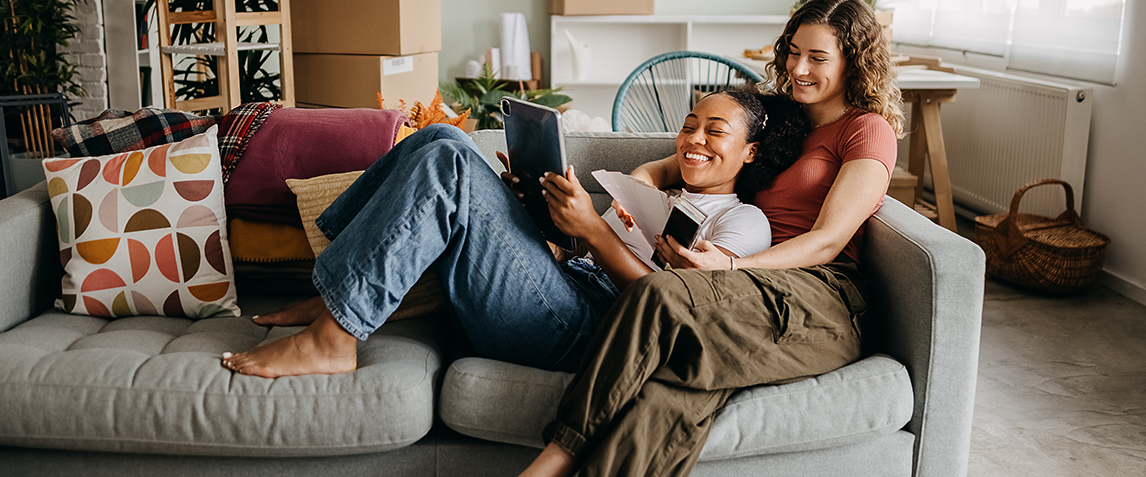 Photo of a couple smiling in their new apartment.