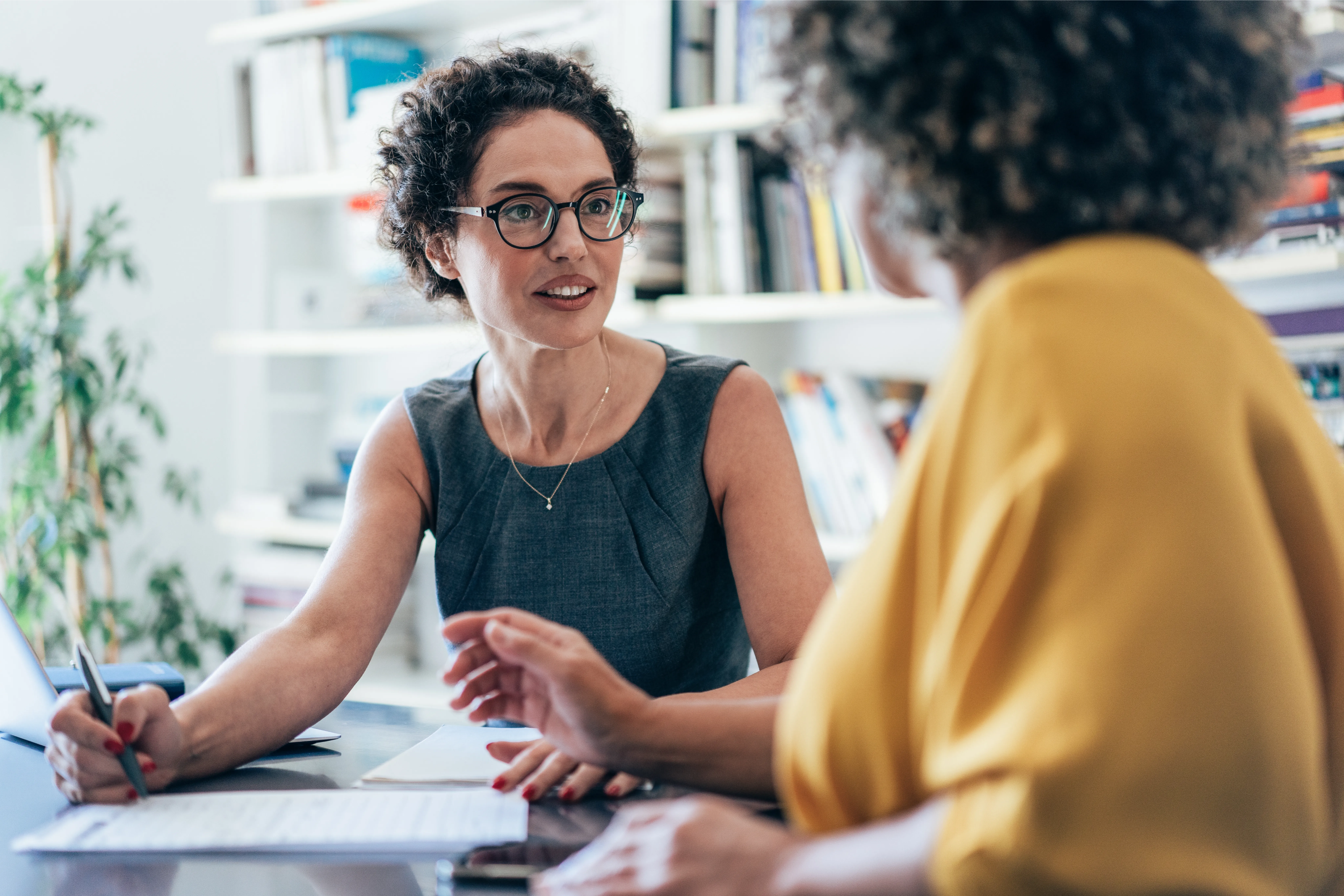 Two women having a conversation in a workplace setting